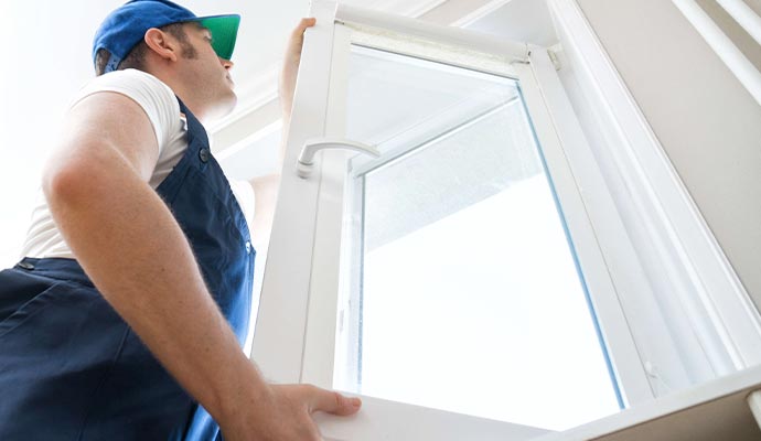 man wear uniformed holding window and replacement window